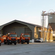 Installation complète à Fahrbinde (Allemagne), composée d’un entrepôt, d’un silo en bois et d’une centrale à saumure, devant lesquels sont stationnés trois camions du service hivernal