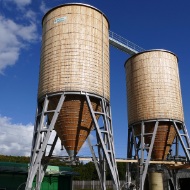 Installation complète à Gesigen, près de Spiez, composée de deux silos ronds en bois reliés par une passerelle de toit en acier