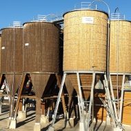 Installation complète à Wolfurt (Autriche) composée de huit silos ronds en bois, avec support, plateforme et échelle en acier