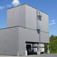Light grey, architectural 450 m³ modular silo with steel ladder, at a maintenance depot
