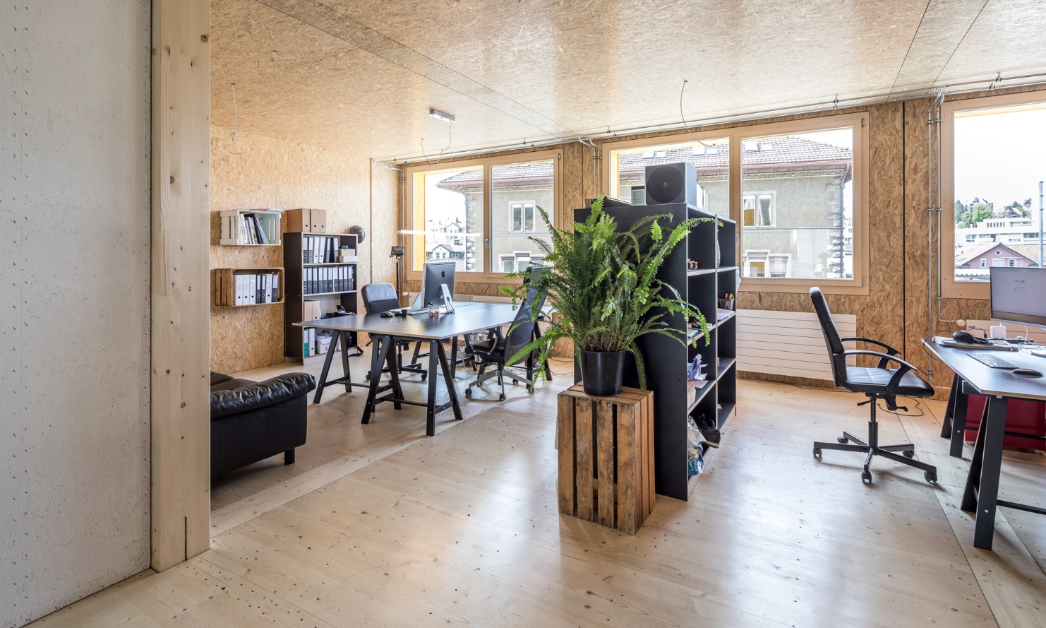 Photograph of an office interior finished entirely in wood with modern furnishing in the Lattich building in St. Gallen