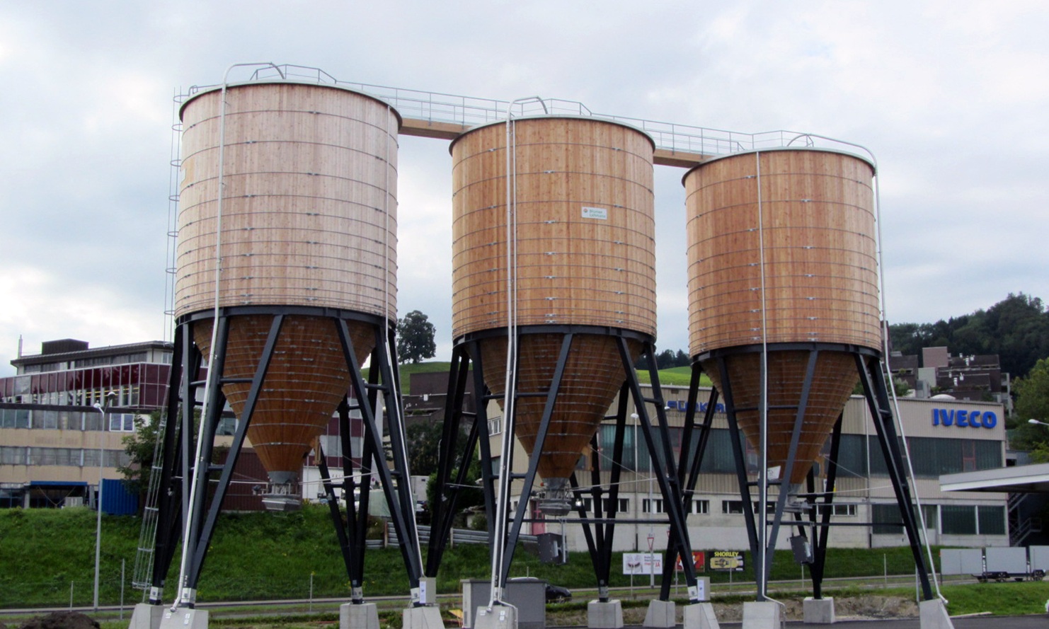 Three round timber silos in a line, connected by a roof crossover, St Gallen Neudorf