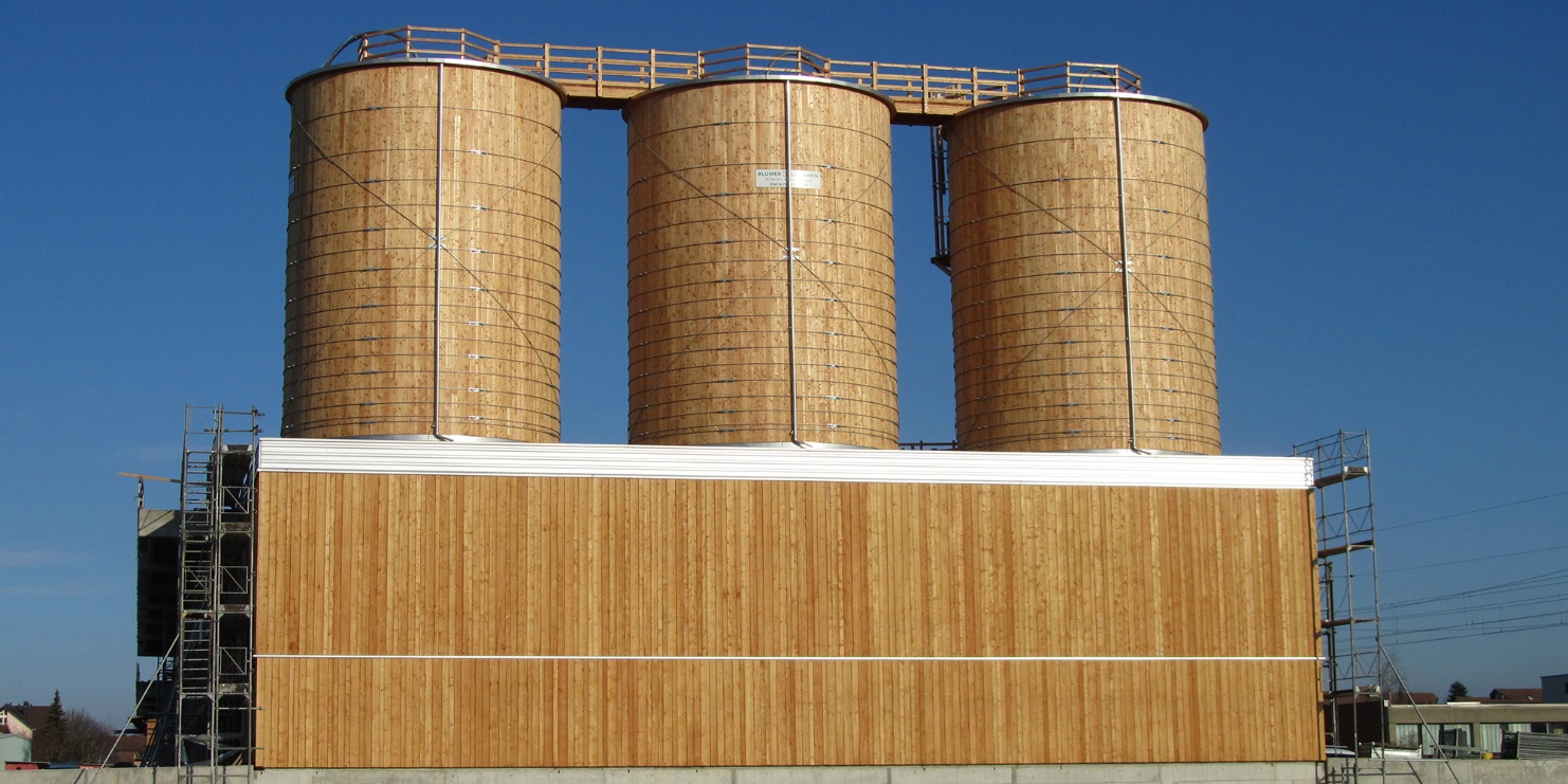 Installation complète intégrée dans le hangar à Eschlikon (CH), composée de trois silos ronds en bois et d’estrades sur le toit, également en bois 