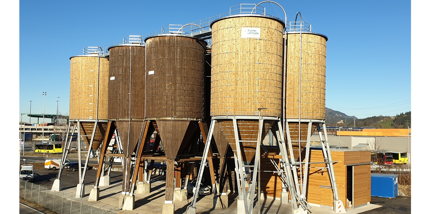 Installation complète à Wolfurt (Autriche) composée de huit silos ronds en bois, avec support, plateforme et échelle en acier