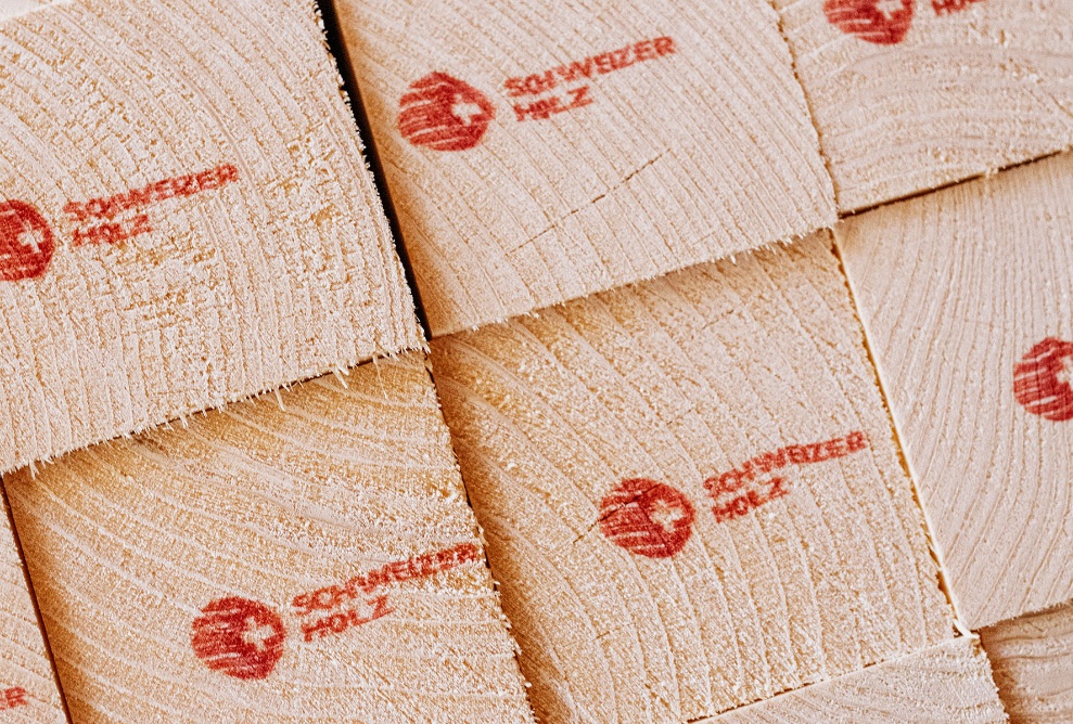 Close-up of square timber, printed with the Swiss timber logo